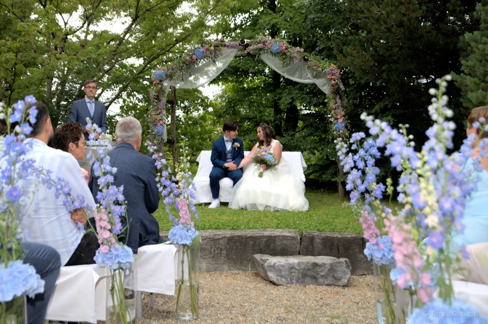 Outdoor Zeremonie unter Blumenbogen – Hochzeitsfotografie Schweiz