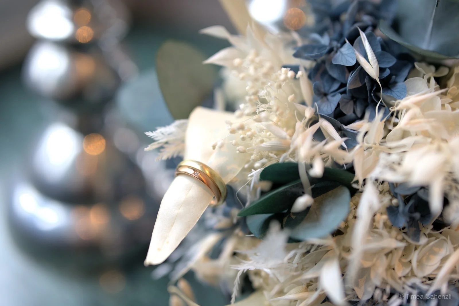 Trauringe auf Brautstrauss mit blauen Hortensien und Trockenblumen – Ringdetail