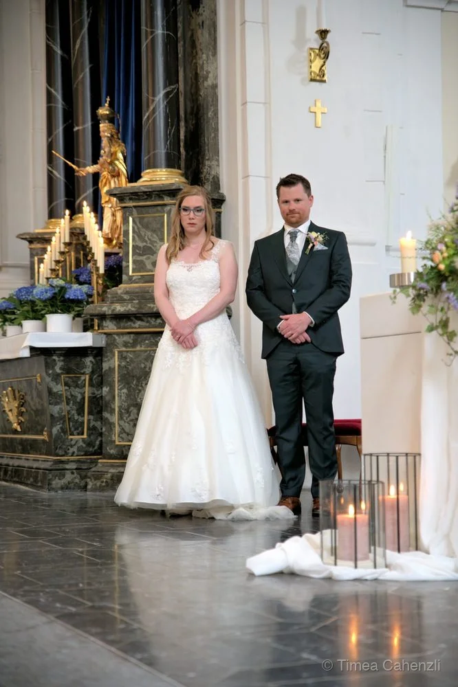 Kirchliche Hochzeit Schweiz – Brautpaar vor Kirche mit Alpenpanorama