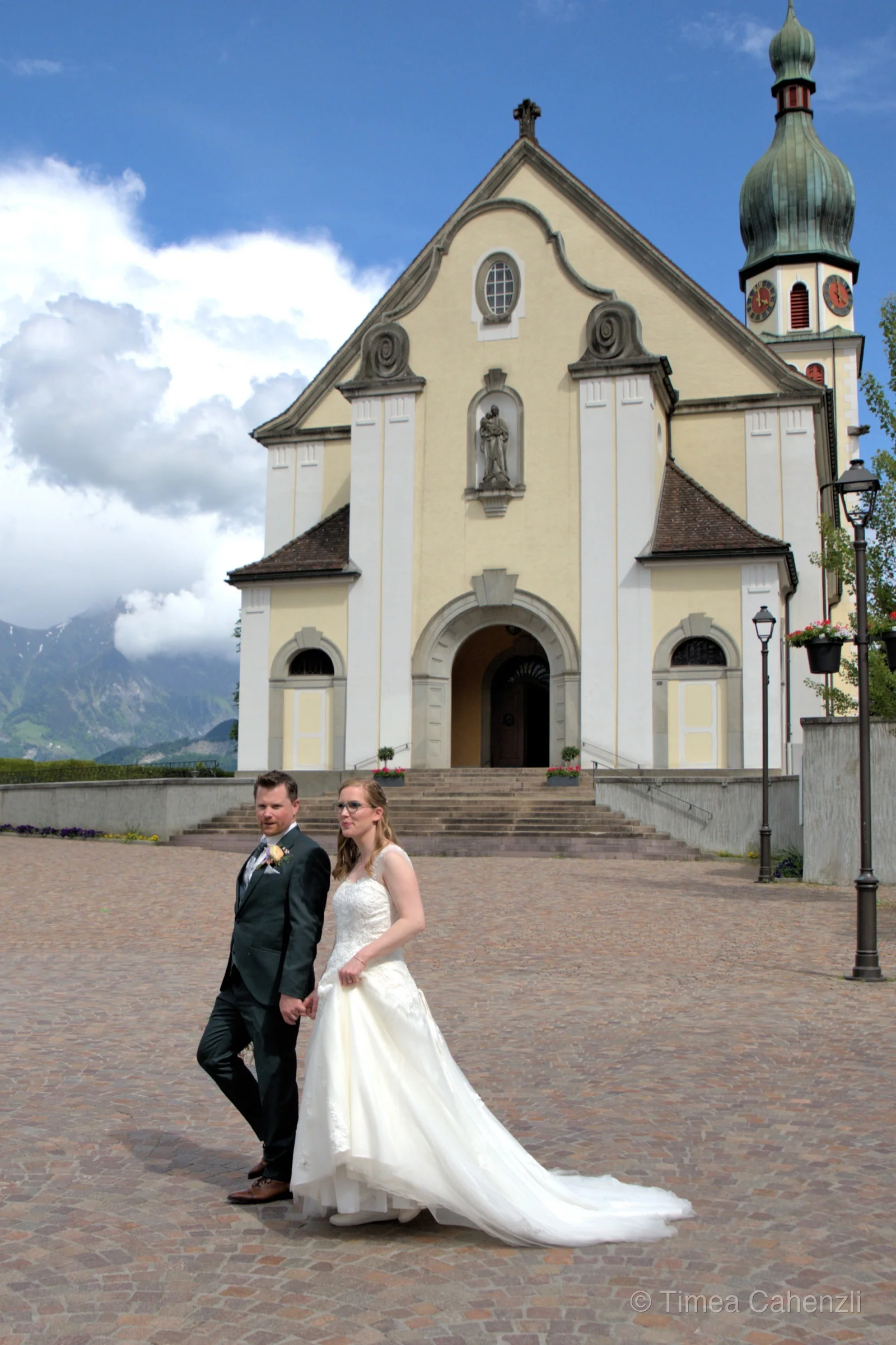 Brautpaar vor Bergkirche – Alpenhochzeit mit Panorama Schweiz